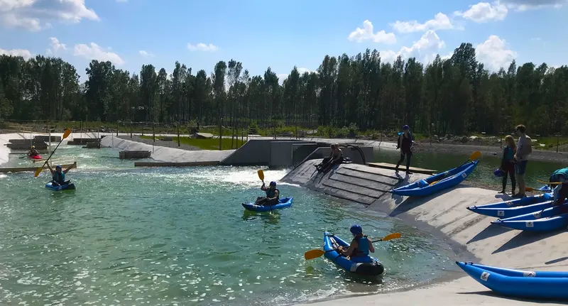 Paddlare i blå uppblåsbara kajaker på forsen vid Falu Vildvattenpark